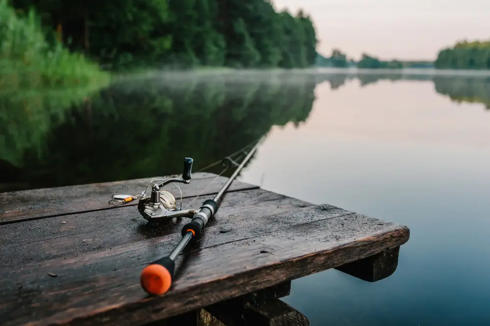 A fishing rod placed on top of a wooden fishing deck